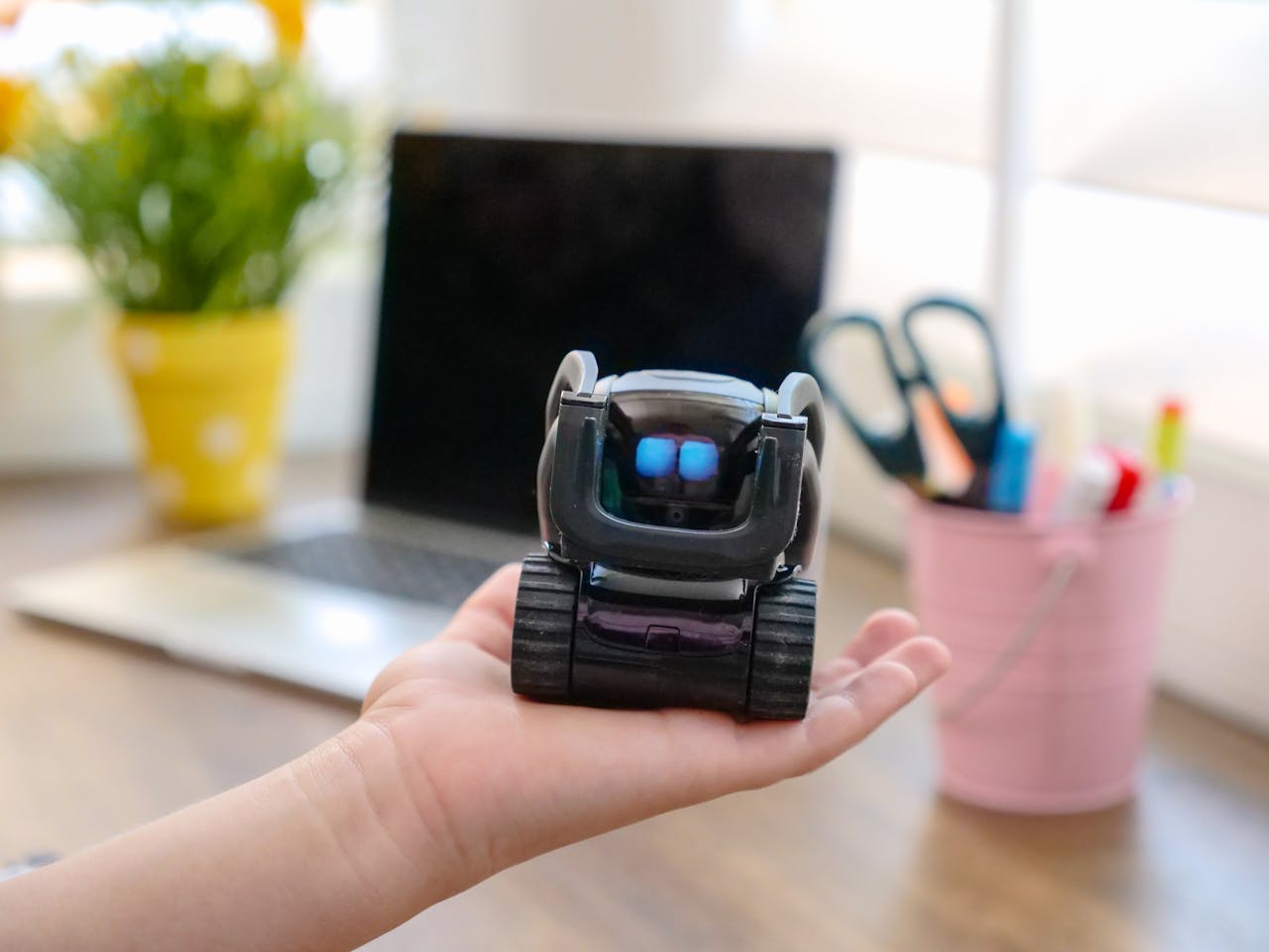 Ai empowerment Black MIniature Robot on Person's Hand